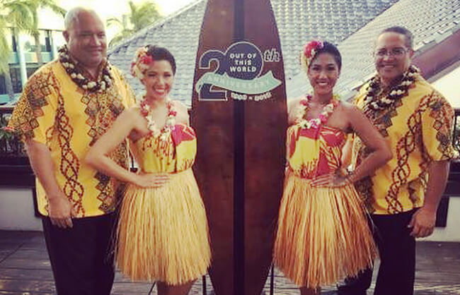 hula dancers in front of surf board